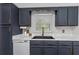 Modern kitchen with dark blue cabinets, white countertops, and stainless steel appliances offers style and functionality at 733 1/2 New Jersey St, Clearwater, FL 33756