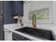 The kitchen features navy cabinets, modern countertops, an updated sink, and stainless steel appliances at 733 1/2 New Jersey St, Clearwater, FL 33756