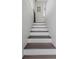 View of staircase with freshly painted white risers and brown treads leading up to the second floor at 733 1/2 New Jersey St, Clearwater, FL 33756