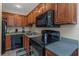 Modern kitchen with wood cabinets, black appliances and double sink at 105 Pompano Se Dr # A, St Petersburg, FL 33705