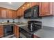 Modern kitchen with wood cabinets, black appliances and a double sink at 105 Pompano Se Dr # A, St Petersburg, FL 33705