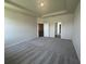Bright bedroom with neutral carpeting features a door that leads to another room or space at 16044 7Th E Ave, Bradenton, FL 34212
