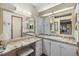 Bathroom features a granite vanity with double sinks and large mirrors at 5802 Cheyenne St, Zephyrhills, FL 33542