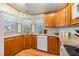 L shaped kitchen with wood cabinets, granite countertops, and modern appliances at 5802 Cheyenne St, Zephyrhills, FL 33542