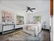 Main bedroom with a ceiling fan, large windows, and a cozy sitting area at 2111 Burlington N Ave, St Petersburg, FL 33713