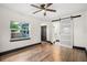 Light and airy bedroom with wood-look flooring and barn door leading to the bathroom at 2111 Burlington N Ave, St Petersburg, FL 33713