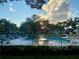 Community pool at sunset with surrounding buildings at 3157 Mission Grove Dr, Palm Harbor, FL 34684