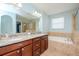 Bathroom with granite countertops, large soaking tub, and walk-in shower at 1307 Pasadena Bloom Ln, Ruskin, FL 33570