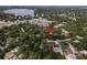Aerial view of the home nestled amongst trees, with lake and other homes in the background at 12318 Woodleigh Ave, Tampa, FL 33612