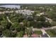 An aerial view of a residential area near a lake, showcasing various homes, landscaping, and a community of townhouses at 12318 Woodleigh Ave, Tampa, FL 33612