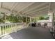 Covered back porch with cozy seating area, wood flooring, and stunning lake view at 12318 Woodleigh Ave, Tampa, FL 33612
