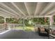 Back porch has cozy seating and a view of trees and the lake at 12318 Woodleigh Ave, Tampa, FL 33612