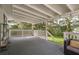 Covered porch featuring wood flooring, white railings, and lake view at 12318 Woodleigh Ave, Tampa, FL 33612