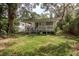 Lush backyard featuring a large green lawn and covered porch at 12318 Woodleigh Ave, Tampa, FL 33612