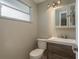 Modern half bathroom with a wood-look vanity, vessel sink and a decorative mirror at 12318 Woodleigh Ave, Tampa, FL 33612