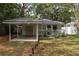 Single story home with a covered carport and small front porch with minimal landscaping at 12318 Woodleigh Ave, Tampa, FL 33612