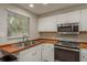 Modern kitchen features white cabinets, butcher block countertops and stainless steel appliances at 12318 Woodleigh Ave, Tampa, FL 33612