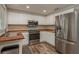 Bright kitchen featuring white cabinets, stainless steel appliances and butcher block countertops at 12318 Woodleigh Ave, Tampa, FL 33612