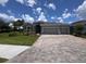 Single-story home featuring a spacious driveway, well-maintained lawn, and a 2-car garage, under a bright blue sky at 4303 Pullet Ct, Lakewood Ranch, FL 34211