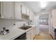 Kitchen featuring white cabinets, a stainless steel sink, and a black dishwasher at 5521 80Th N St # 310, St Petersburg, FL 33709