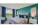 Main bedroom with teal accent wall and plush bedding at 18326 Wheathouse Pl, Lakewood Ranch, FL 34211