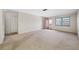 Spacious condo living room with neutral carpeting and sliding door to balcony at 5521 80Th N St # 310, St Petersburg, FL 33709
