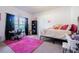 Charming bedroom featuring a full-size bed, pink rug, and a workspace at 19501 Sea Myrtle Way, Tampa, FL 33647