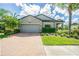 Front view of a two-story house with gray exterior, landscaping, and a brick driveway at 19501 Sea Myrtle Way, Tampa, FL 33647