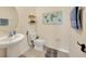 Clean and bright bathroom with pedestal sink, toilet, and decorative artwork at 5674 Banbury Ridge Run, Wesley Chapel, FL 33545