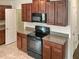 Kitchen with dark wood cabinets and black appliances at 2110 Purple Orchid Pl, Ruskin, FL 33570