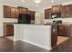 Modern kitchen features dark wood cabinets, black appliances, and an island at 2110 Purple Orchid Pl, Ruskin, FL 33570