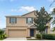 Two story home with tan exterior, gray shutters, and a two-car garage at 2110 Purple Orchid Pl, Ruskin, FL 33570
