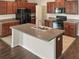 Modern kitchen featuring dark wood cabinets, granite countertops, and a large island at 2110 Purple Orchid Pl, Ruskin, FL 33570