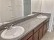 Bathroom with double sinks, granite countertop, and dark wood cabinets at 2110 Purple Orchid Pl, Ruskin, FL 33570