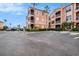 Exterior of a light peach colored building with balconies and lush landscaping at 5000 Culbreath Key Way # 1-212, Tampa, FL 33611