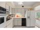 White cabinets, black appliances, and a microwave in this kitchen at 2358 Ecuadorian Way # 56, Clearwater, FL 33763