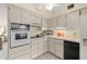 View of kitchen with white cabinets, built-in oven, and microwave at 2358 Ecuadorian Way # 56, Clearwater, FL 33763
