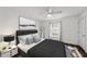 Cozy bedroom with a queen-size bed, dark gray bedding, and a window with natural light at 2220 Linda Ln, Lutz, FL 33558