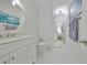 Bright bathroom with white vanity, toilet, and hexagon tile flooring, featuring modern fixtures and ample lighting at 415 Islebay Dr, Apollo Beach, FL 33572