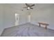 Spacious bedroom featuring plush carpeting, a ceiling fan, and convenient access to both the bathroom and hallway at 415 Islebay Dr, Apollo Beach, FL 33572