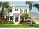 Beautiful two-story home featuring a lush lawn, mature palm trees, and teal window shutters at 415 Islebay Dr, Apollo Beach, FL 33572