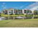 Condo building with water feature and palm trees in front at 50 Coe Rd # 224, Belleair, FL 33756