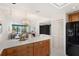 Bright kitchen with wood cabinets, white countertops, and a view of the living room and waterfront at 50 Coe Rd # 224, Belleair, FL 33756
