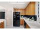 Kitchen with black appliances and wood cabinets at 50 Coe Rd # 224, Belleair, FL 33756
