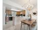 Open concept kitchen and dining area with wood cabinetry, breakfast bar, and modern chandelier at 50 Coe Rd # 224, Belleair, FL 33756