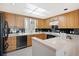 Bright kitchen with wood cabinets, breakfast bar, and modern appliances at 50 Coe Rd # 224, Belleair, FL 33756
