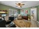Living room features a ceiling fan, comfortable seating and a home office area at 35027 Wagner Way, Zephyrhills, FL 33541
