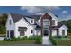 Stunning two-story home with modern farmhouse exterior, landscaping, and attached garage at 8100 Spring Forest Ln, Wesley Chapel, FL 33544