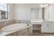 Bathroom with a soaking tub, white cabinets, and tiled floor at 12977 Long Valley Cir, Spring Hill, FL 34609