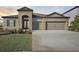 Beautiful home exterior with stone accents, a three-car garage, and well-manicured lawn at 12977 Long Valley Cir, Spring Hill, FL 34609